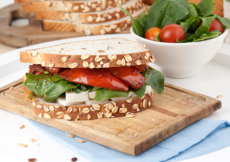 Sándwich Oroweat de pimientos y tomates asados con queso curado. 